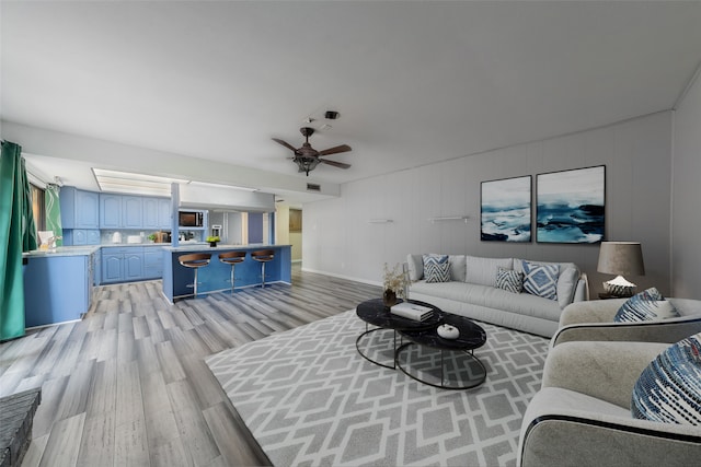 living room with ceiling fan and light hardwood / wood-style floors