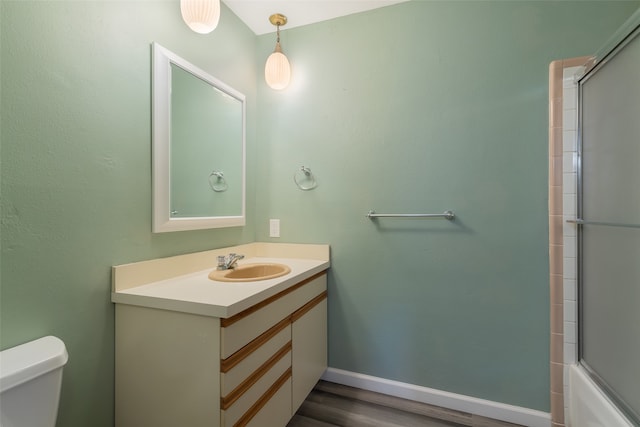 full bathroom featuring shower / bath combination with glass door, toilet, vanity, and hardwood / wood-style flooring