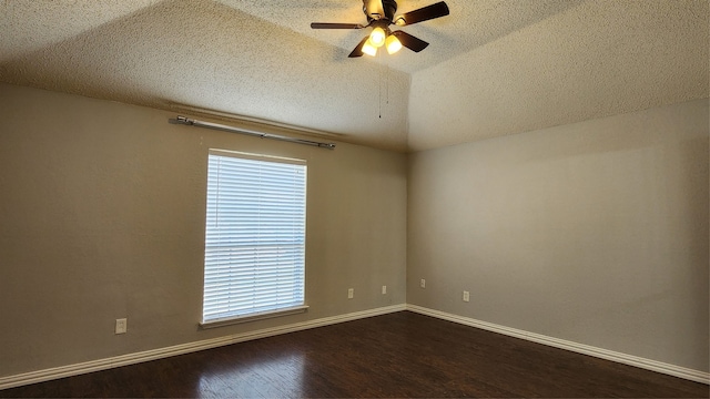 empty room featuring vaulted ceiling, ceiling fan, dark wood-type flooring, and a textured ceiling