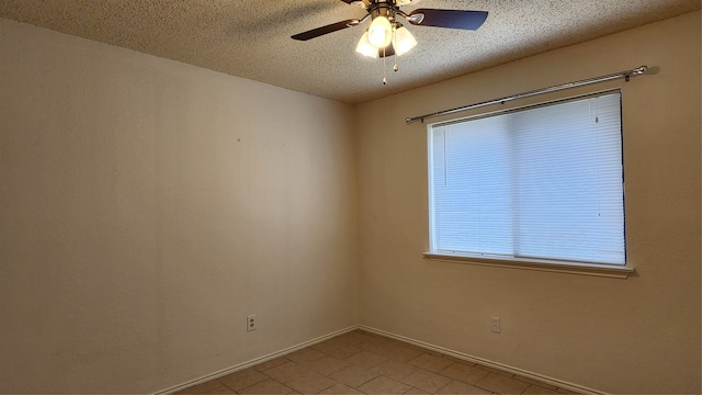 tiled empty room with ceiling fan and a textured ceiling