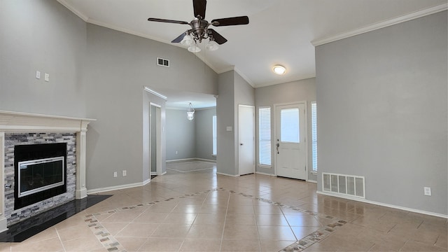 entryway with ceiling fan, crown molding, high vaulted ceiling, a stone fireplace, and light tile patterned flooring