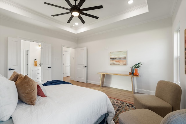 bedroom featuring ceiling fan, crown molding, light hardwood / wood-style floors, and a raised ceiling