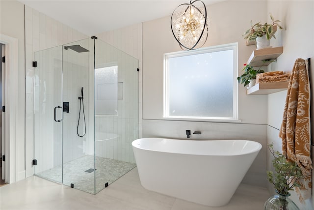 bathroom with a notable chandelier, shower with separate bathtub, and tile walls