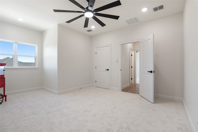 unfurnished bedroom featuring light carpet and ceiling fan