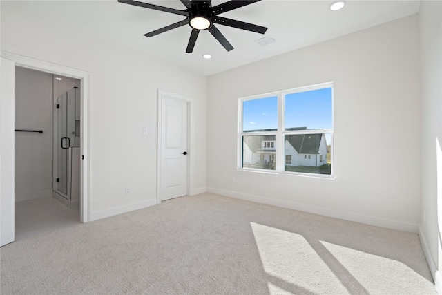 unfurnished bedroom with ceiling fan, ensuite bath, and light carpet