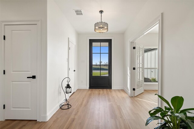 foyer featuring light hardwood / wood-style flooring and an inviting chandelier