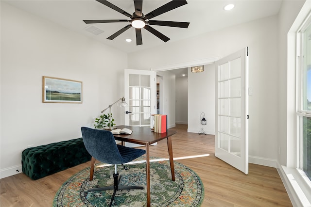 home office featuring ceiling fan, light hardwood / wood-style floors, and french doors