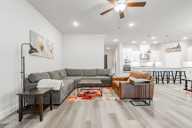 living room featuring light hardwood / wood-style flooring and ceiling fan