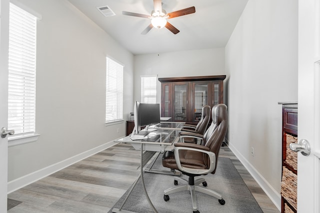 home office with ceiling fan and light hardwood / wood-style floors