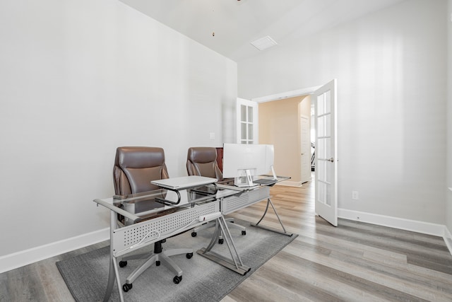 home office with french doors and light wood-type flooring