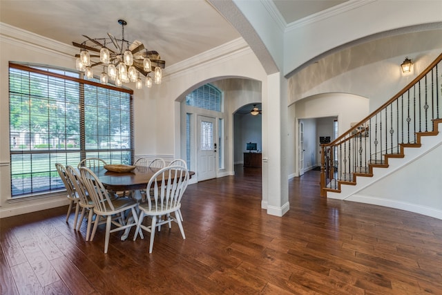 dining area with ceiling fan with notable chandelier, dark hardwood / wood-style flooring, ornamental molding, and a wealth of natural light