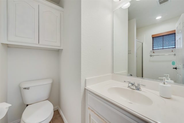 bathroom featuring vanity, an enclosed shower, and toilet