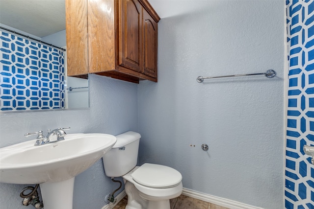 bathroom featuring sink, toilet, and a textured ceiling