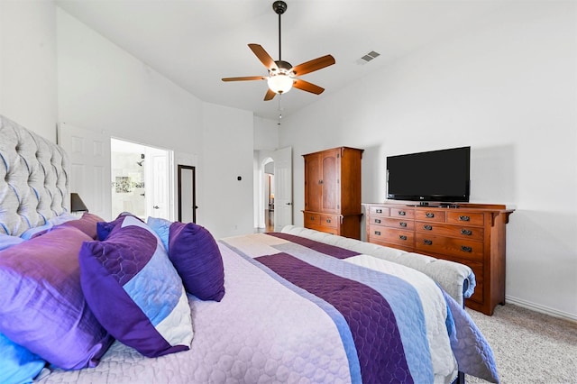 carpeted bedroom with ceiling fan and high vaulted ceiling