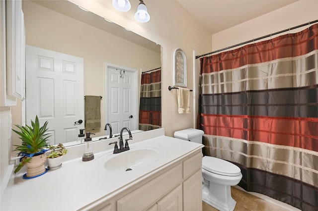 bathroom with toilet, vanity, and tile patterned flooring