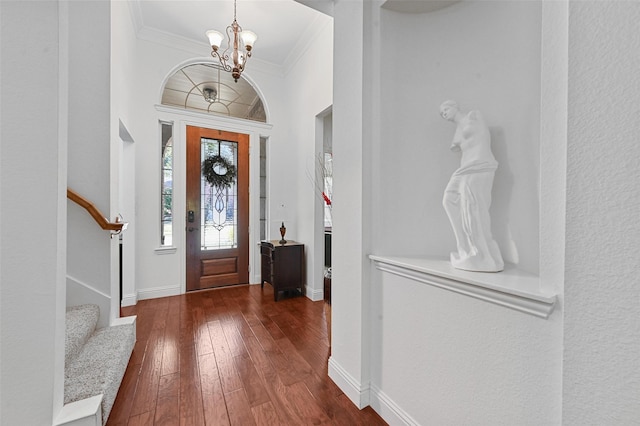 entryway featuring dark hardwood / wood-style flooring, a chandelier, and crown molding