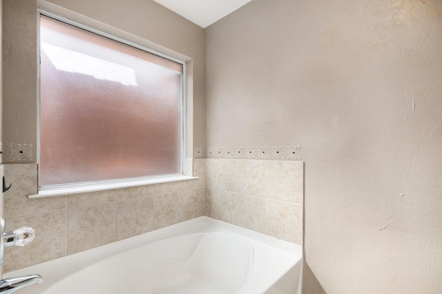 bathroom featuring a bathing tub and a wealth of natural light