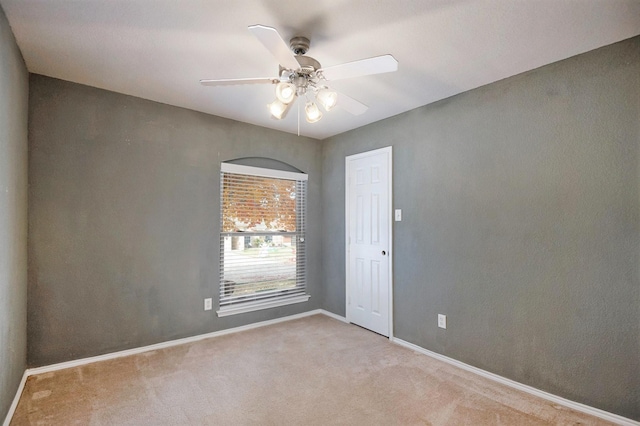 unfurnished room featuring light colored carpet and ceiling fan