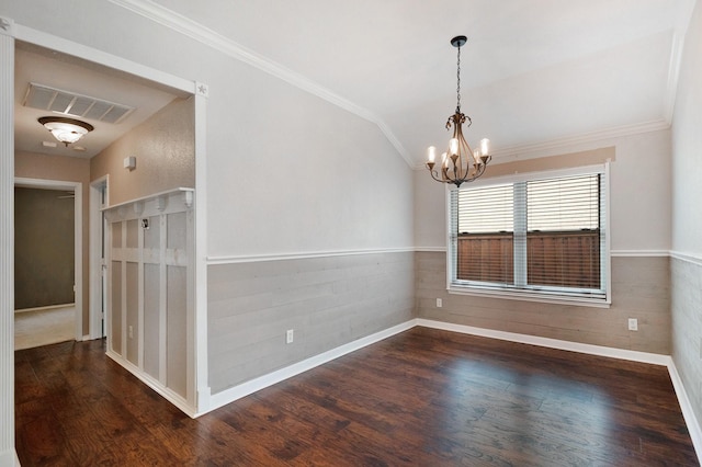 spare room featuring dark hardwood / wood-style flooring, ornamental molding, and a chandelier