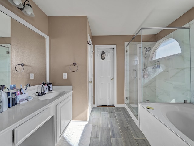 bathroom featuring wood-type flooring, vanity, and separate shower and tub