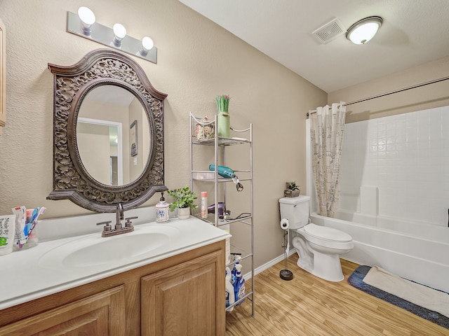 full bathroom with wood-type flooring, vanity, shower / tub combo, and toilet