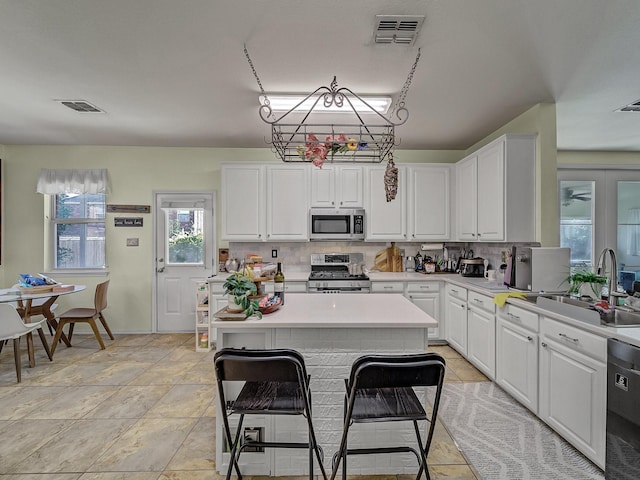 kitchen featuring white cabinets, decorative backsplash, sink, and appliances with stainless steel finishes