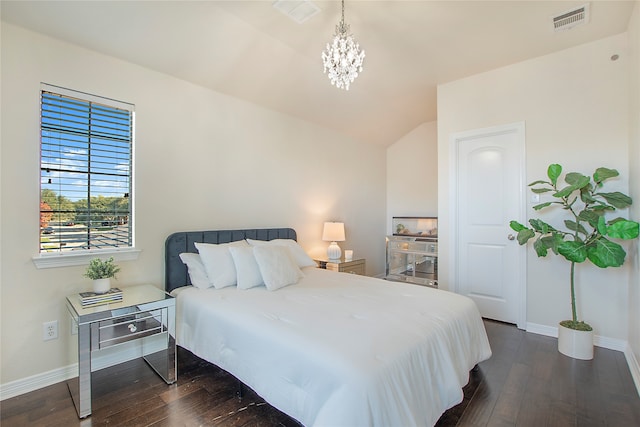 bedroom with lofted ceiling, an inviting chandelier, and dark wood-type flooring