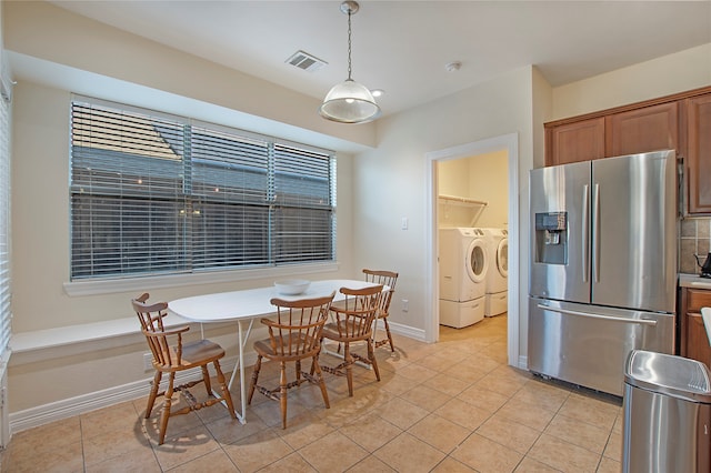 dining room with separate washer and dryer and light tile patterned floors