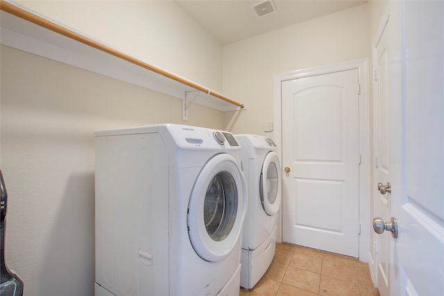 laundry area featuring light tile patterned floors and washer and clothes dryer