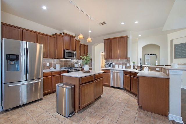 kitchen with a center island, backsplash, hanging light fixtures, kitchen peninsula, and stainless steel appliances