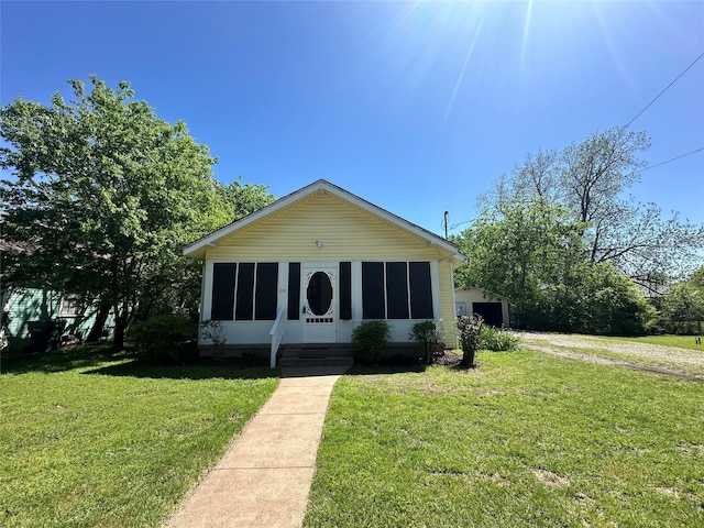 view of front of house with a front yard, a garage, and an outdoor structure