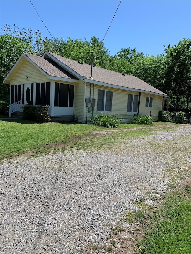 ranch-style house with a front lawn and a sunroom