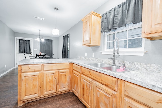 kitchen featuring kitchen peninsula, dark hardwood / wood-style flooring, light brown cabinets, a notable chandelier, and hanging light fixtures