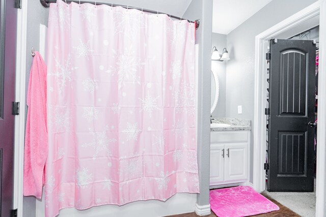 bathroom featuring vanity and shower / bathtub combination with curtain