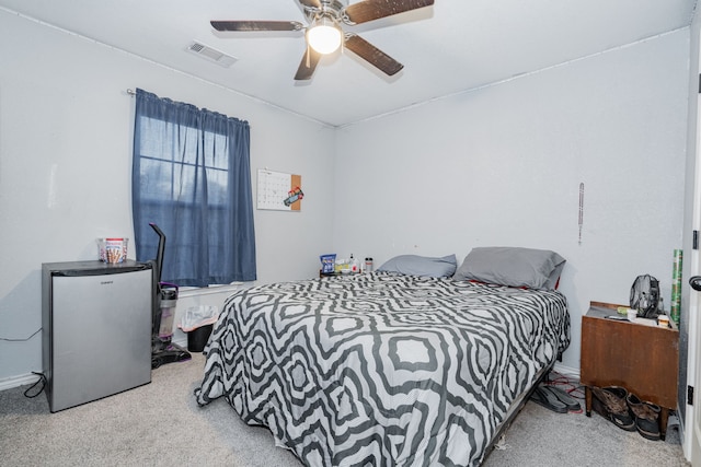 bedroom with ceiling fan, refrigerator, and light carpet