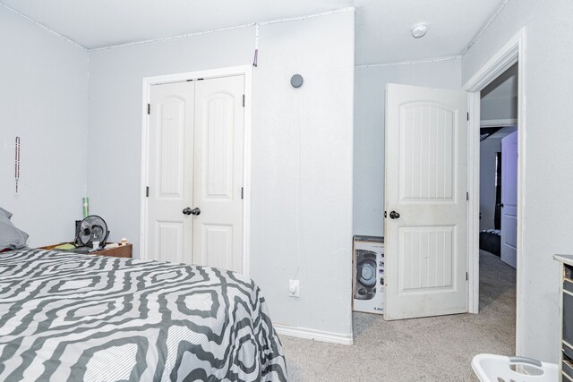 bedroom featuring a closet, light colored carpet, and washer / dryer