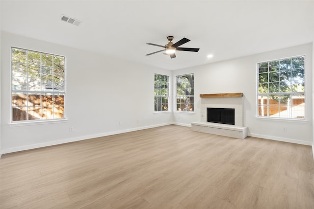 unfurnished living room featuring a wealth of natural light and light hardwood / wood-style floors