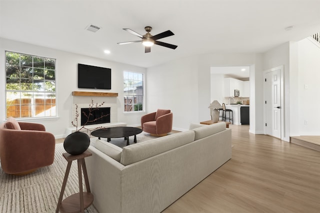 living room with wood-type flooring and ceiling fan