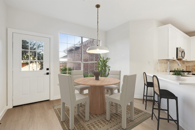 dining room with sink and light wood-type flooring