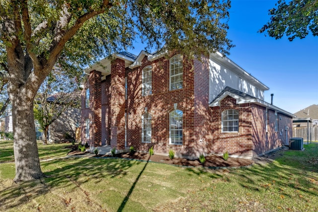 view of front of property with a front lawn and central air condition unit