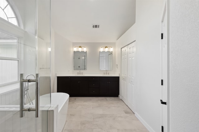 bathroom with vanity and shower with separate bathtub