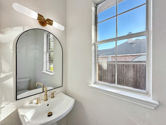 bathroom with sink, a healthy amount of sunlight, and toilet