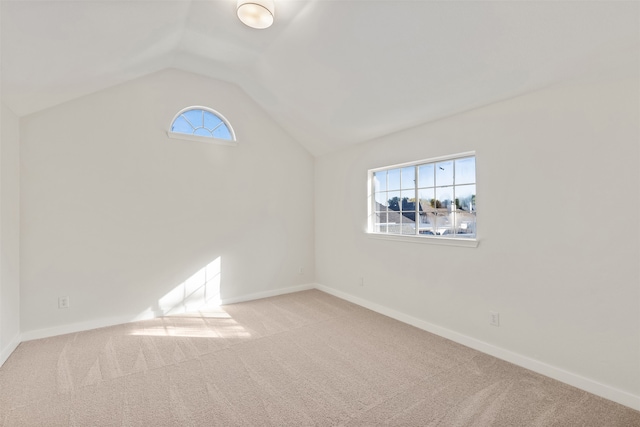 carpeted spare room featuring lofted ceiling