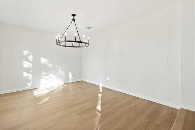 unfurnished dining area with light hardwood / wood-style flooring and a chandelier