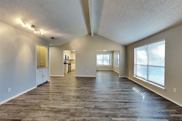 unfurnished living room with dark hardwood / wood-style flooring, a textured ceiling, and vaulted ceiling