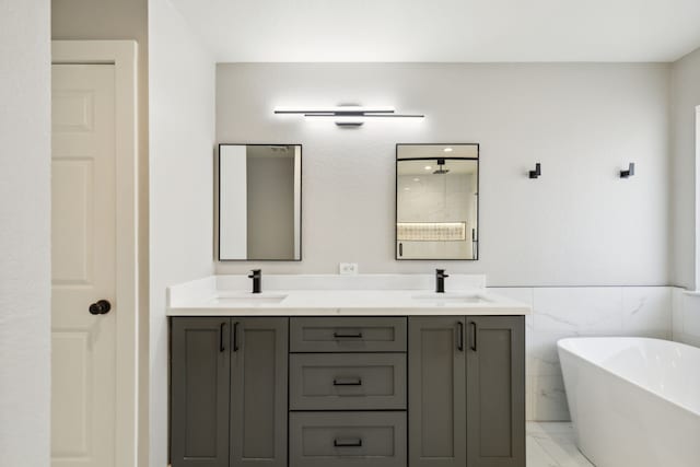 bathroom featuring vanity, a bath, and tile walls