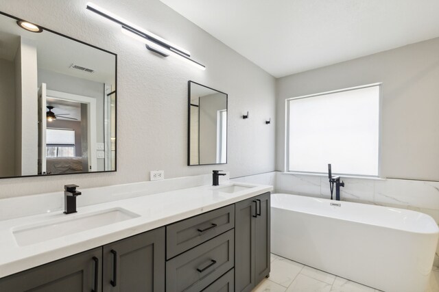 bathroom with a tub to relax in, ceiling fan, and vanity