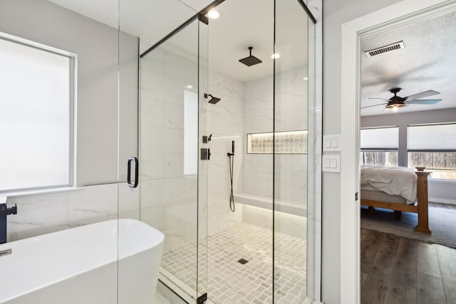 bathroom with ceiling fan, hardwood / wood-style floors, tile walls, and shower with separate bathtub