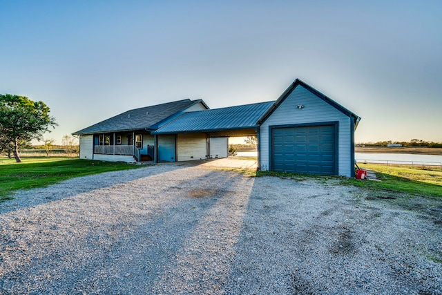 view of front of home with a yard, a porch, and a garage