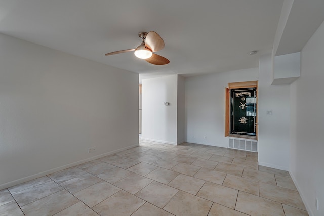 tiled spare room with ceiling fan